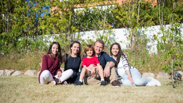 A joyful family enjoying sunny moments in a lush Portuguese garden.